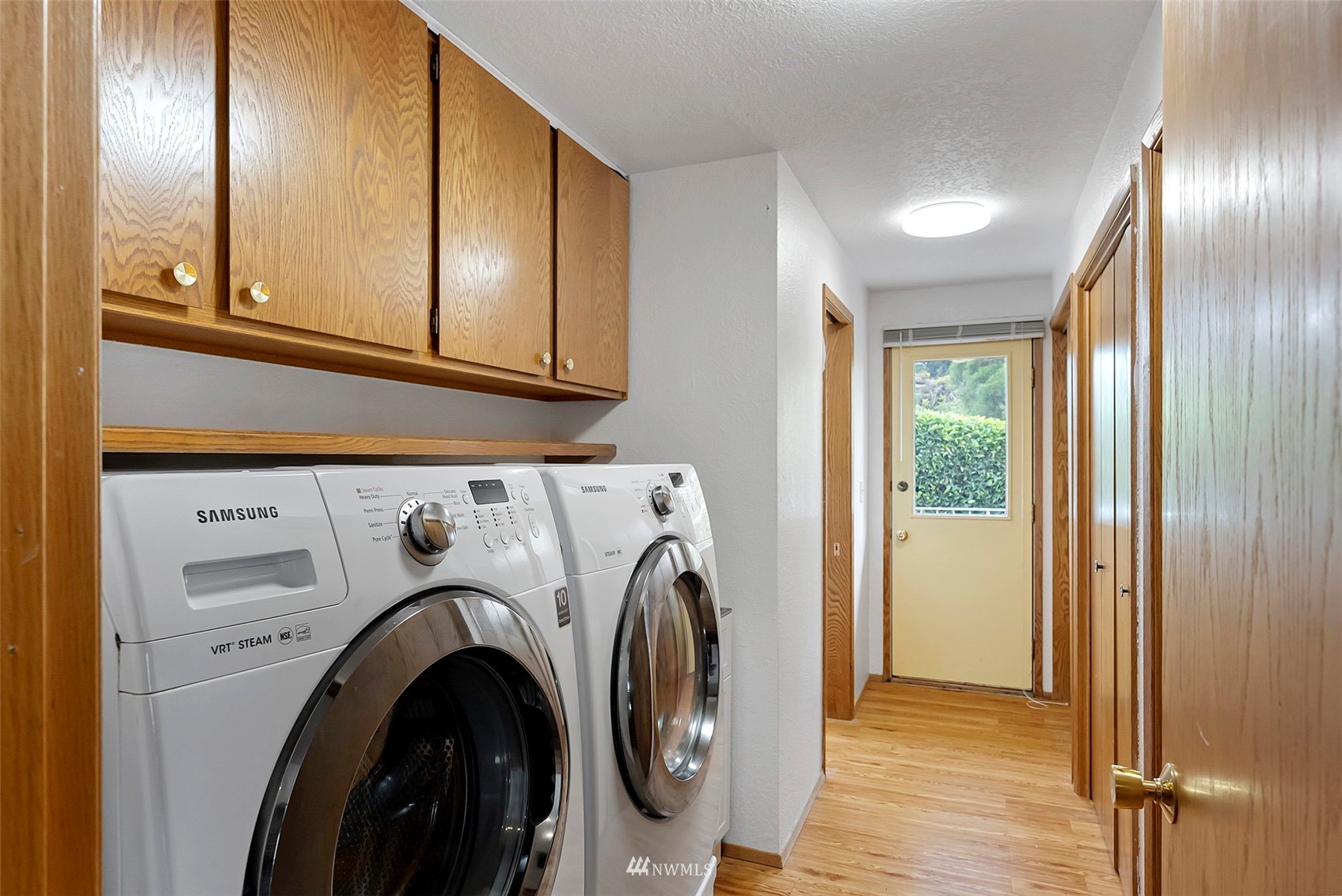 3891 Rama Drive East Port Orchard, WA 98366 - Photo 22 of 32 a view of washer and dryer with kitchen in the background