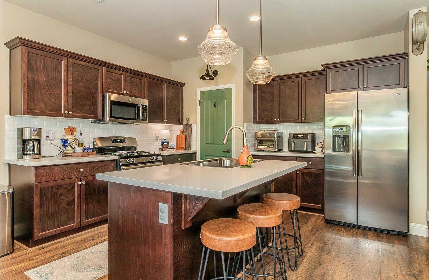 2716 Pontiac Avenue Clovis, CA 93611 - Photo 12 of 32 a kitchen with stainless steel appliances a dining table chairs refrigerator and microwave