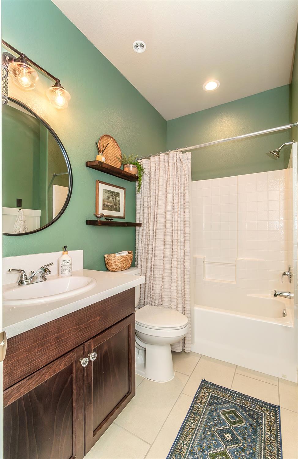2716 Pontiac Avenue Clovis, CA 93611 - Photo 23 of 32 a bathroom with a sink a toilet and a mirror