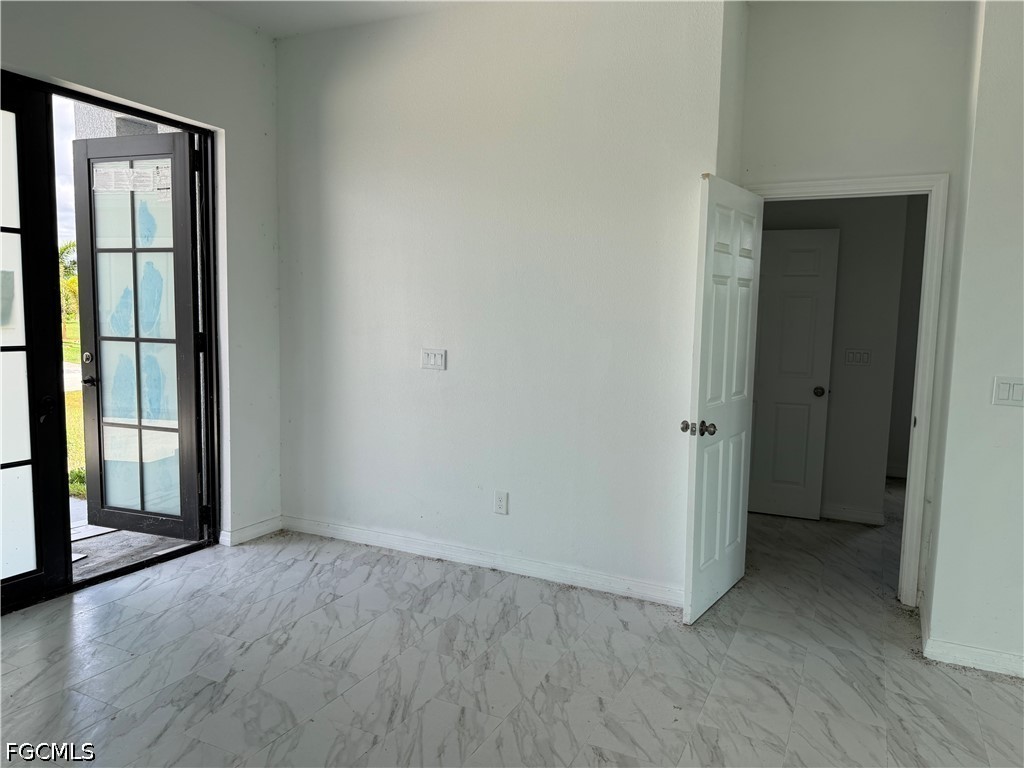 10658 Rainsville Street Port Charlotte, FL 33981 - Photo 4 of 21 an empty room with wooden floor and windows