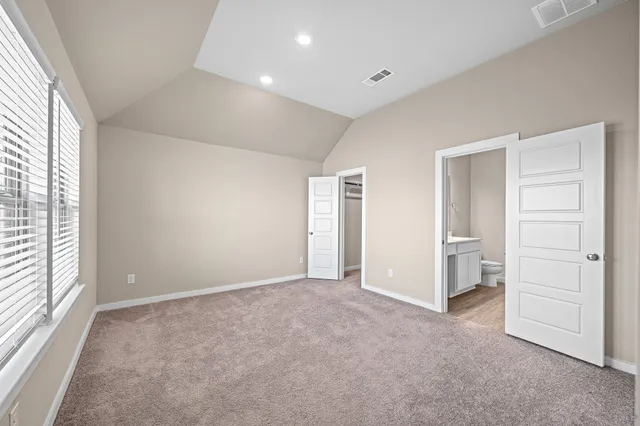 an empty room with a window and a kitchen