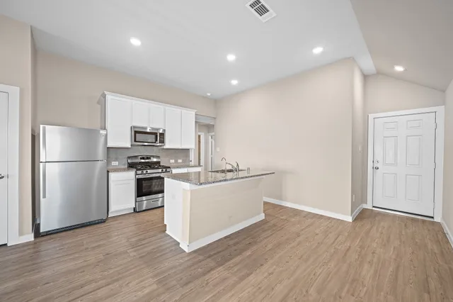 a kitchen with white cabinets and stainless steel appliances