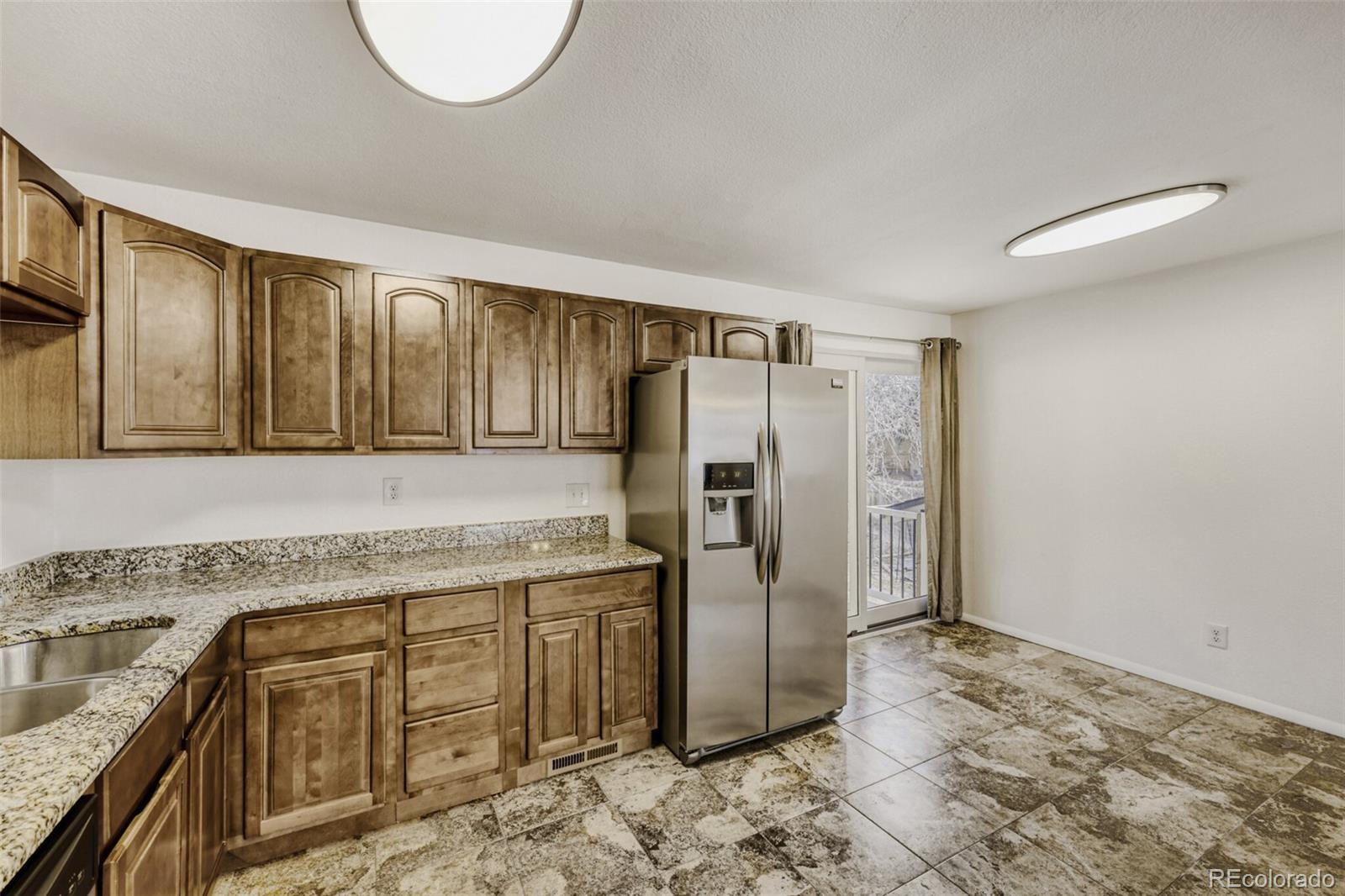 9168 Flower Court Westminster, CO 80021 - Photo 13 of 38 a kitchen with stainless steel appliances granite countertop a refrigerator and a sink