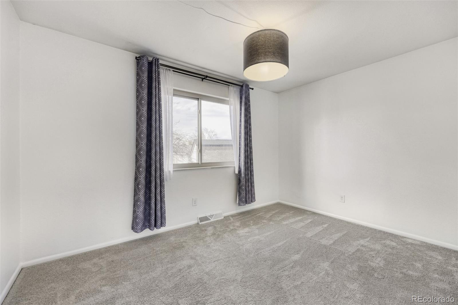 9168 Flower Court Westminster, CO 80021 - Photo 15 of 38 an empty room with wooden floor and windows