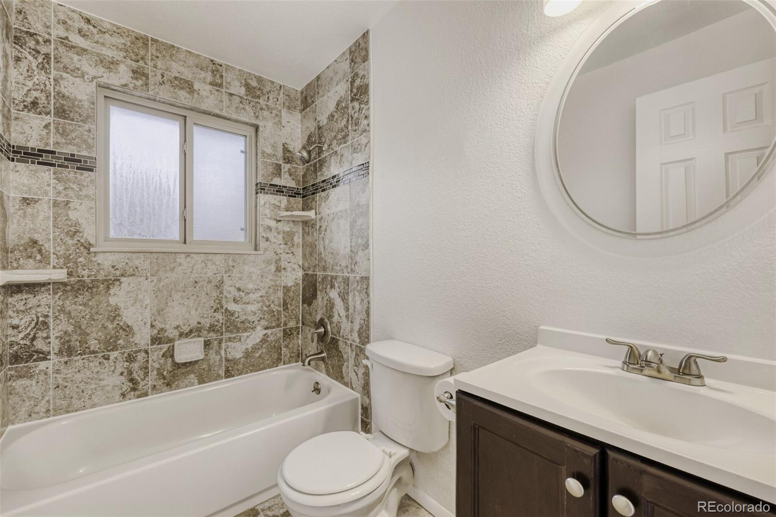 9168 Flower Court Westminster, CO 80021 - Photo 17 of 38 a bathroom with a sink a toilet and a bathtub