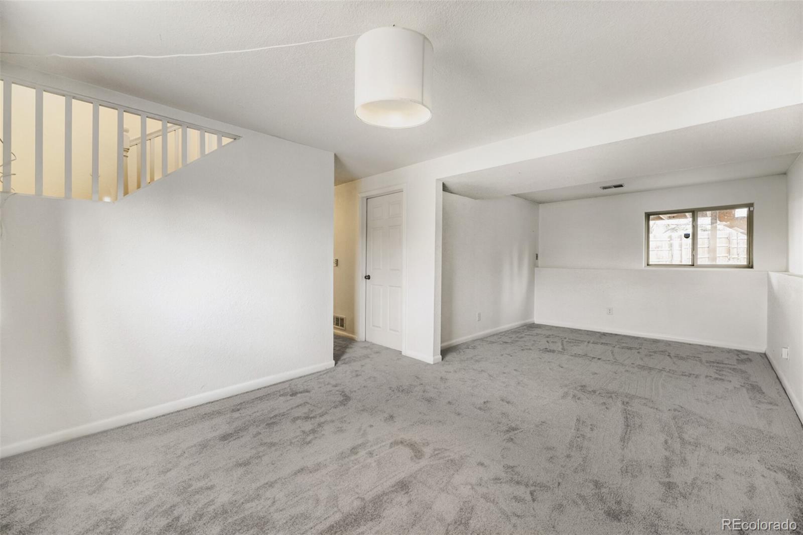 9168 Flower Court Westminster, CO 80021 - Photo 22 of 38 a view of an empty room with windows