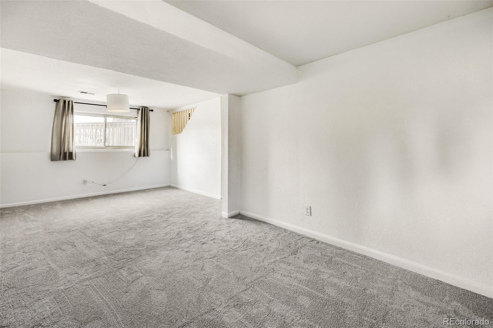 9168 Flower Court Westminster, CO 80021 - Photo 25 of 38 an empty room with windows and refrigerator
