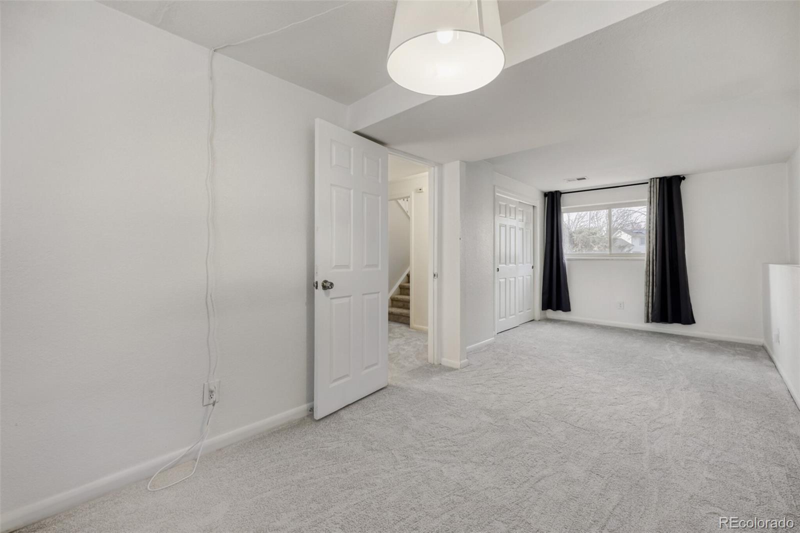 9168 Flower Court Westminster, CO 80021 - Photo 29 of 38 an empty room with windows and closet