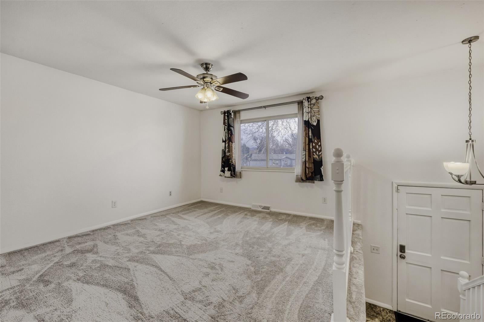 9168 Flower Court Westminster, CO 80021 - Photo 6 of 38 a view of a livingroom with a chandelier fan and wooden floor