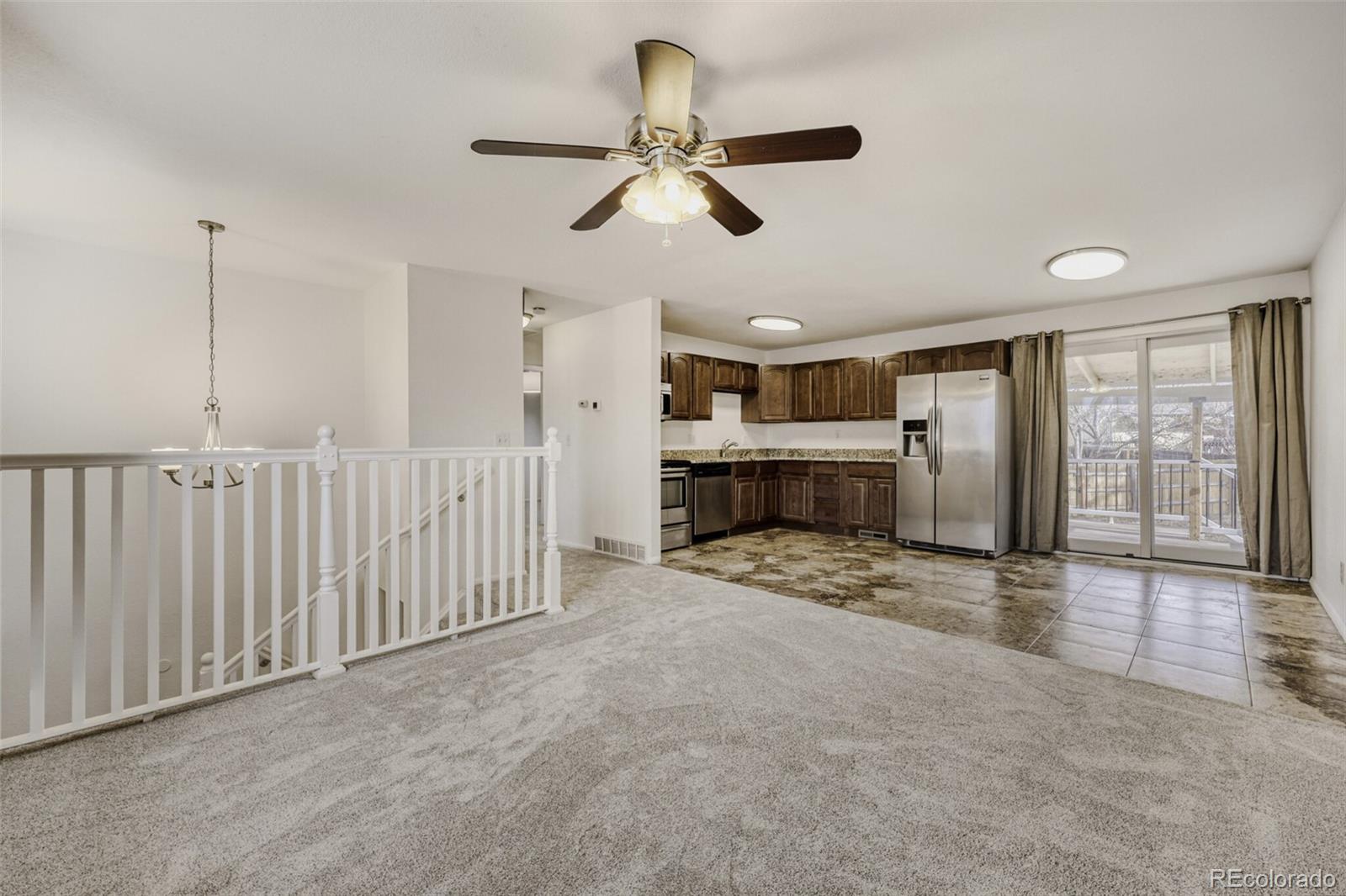 9168 Flower Court Westminster, CO 80021 - Photo 9 of 38 a view of empty room with fireplace and ceiling fan