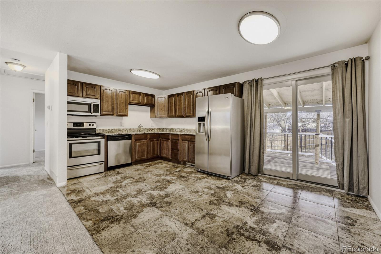 9168 Flower Court Westminster, CO 80021 - Photo 10 of 38 a kitchen with granite countertop a refrigerator and a sink