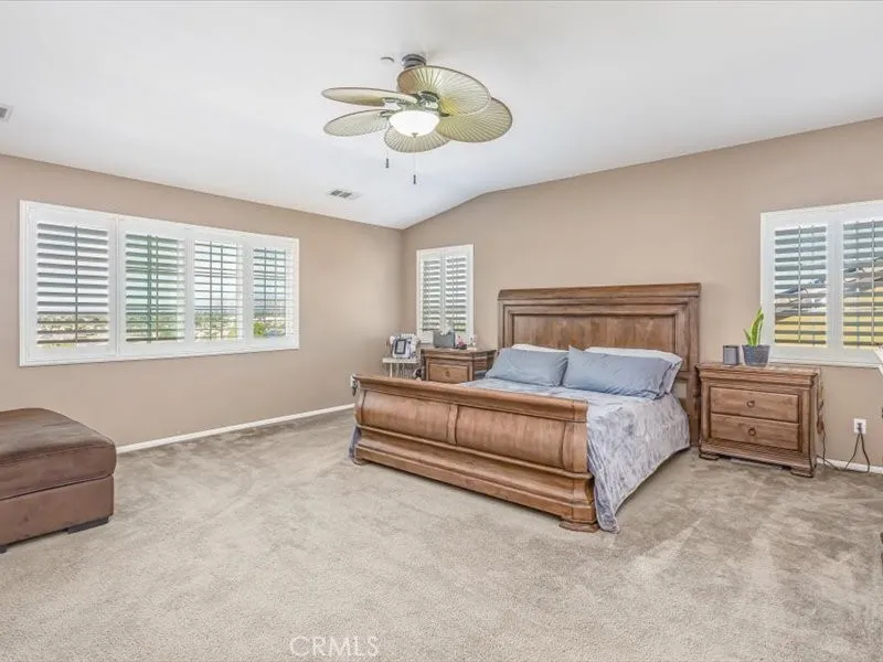 15851 Sulphur Springs Road Moreno Valley, CA 92555 - Photo 36 of 47 a spacious bedroom with a bed and a chandelier