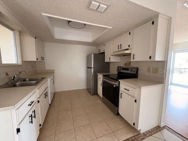 a kitchen with stainless steel appliances a sink stove and cabinets