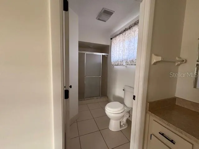 a bathroom with a granite countertop toilet a sink and shower
