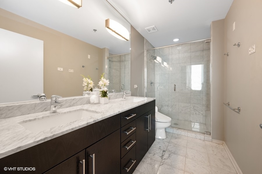 123 South Green Street, Unit 201B Chicago, IL 60607 - Photo 12 of 19 a bathroom with a granite countertop sink a toilet and a shower