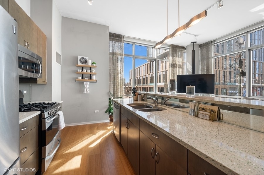 123 South Green Street, Unit 201B Chicago, IL 60607 - Photo 8 of 19 a kitchen with stainless steel appliances granite countertop a sink stove and refrigerator