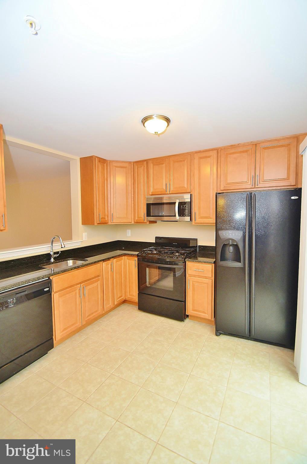 1331 Hazel Street Baltimore, MD 21226 - Photo 7 of 19 a kitchen with stainless steel appliances granite countertop a refrigerator a stove a sink and a microwave