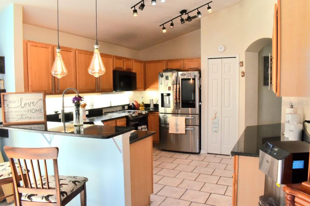 13541 Tetherline Trail Orlando, FL 32837 - Photo 11 of 39 a kitchen with stainless steel appliances kitchen island granite countertop a refrigerator and a stove top oven