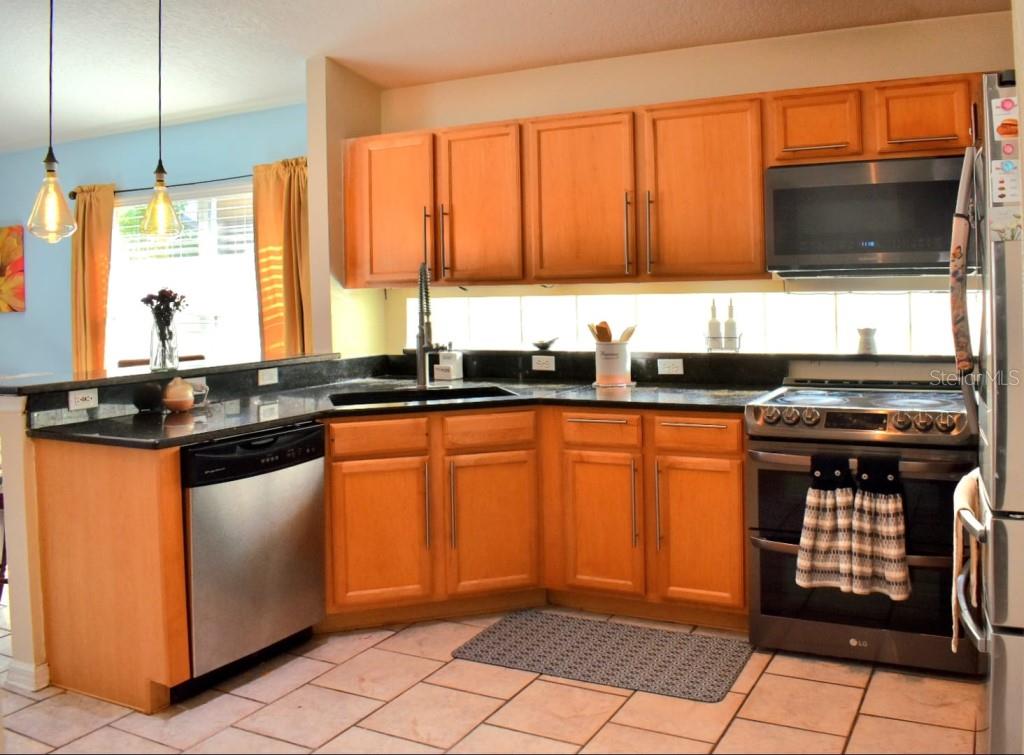 13541 Tetherline Trail Orlando, FL 32837 - Photo 12 of 39 a kitchen with stainless steel appliances granite countertop a stove a sink and a microwave