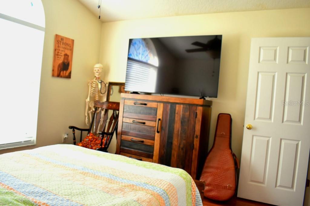 13541 Tetherline Trail Orlando, FL 32837 - Photo 22 of 39 a bedroom with a bed and wooden floor