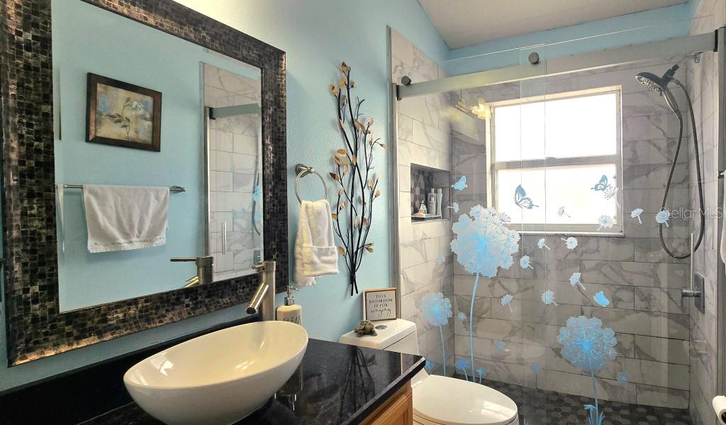13541 Tetherline Trail Orlando, FL 32837 - Photo 26 of 39 a bathroom with a toilet sink a mirror and a shower