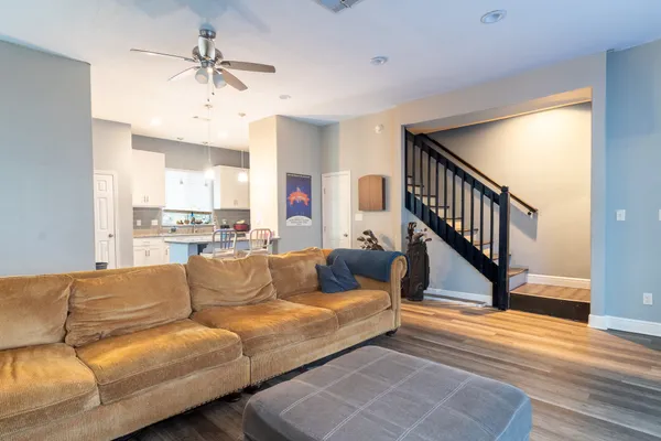 a living room with furniture and a wooden floor