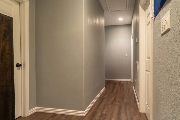 a view of a hallway with wooden floor