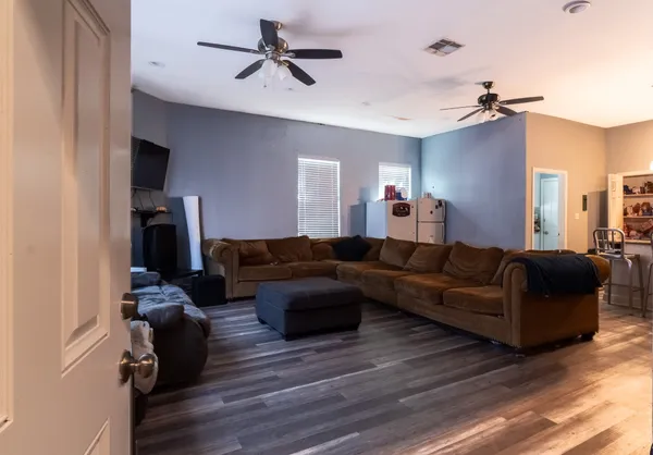 a living room with furniture and a wooden floor