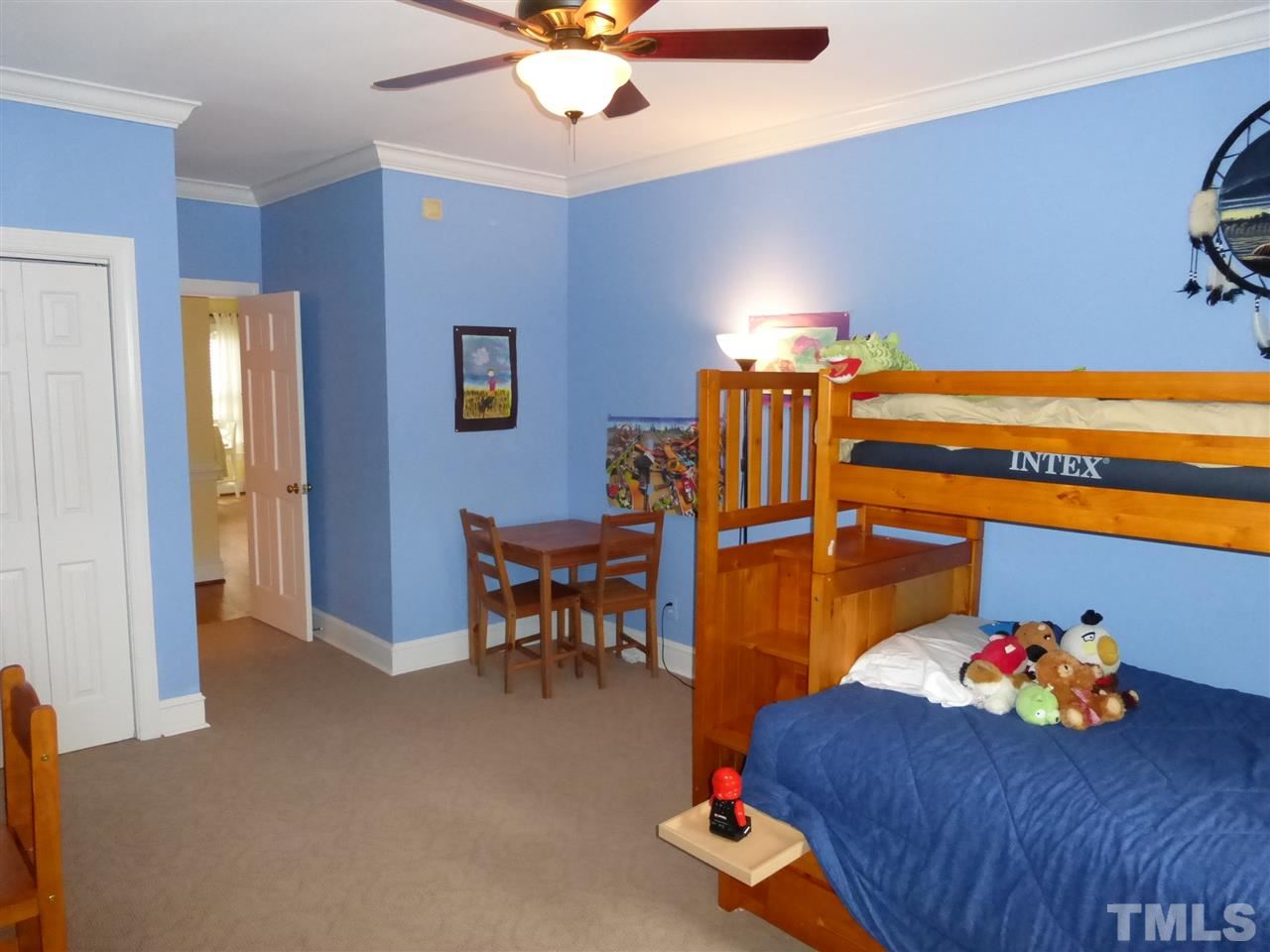 6846 Gloucester Road Raleigh, NC 27612 - Photo 11 of 18 a bedroom with furniture and a chandelier