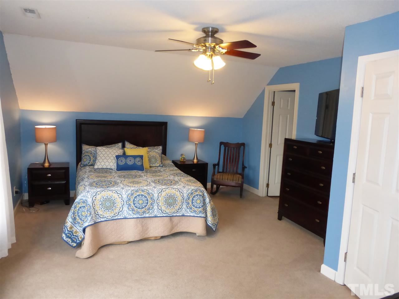 6846 Gloucester Road Raleigh, NC 27612 - Photo 12 of 18 a spacious bedroom with a bed and a chandelier