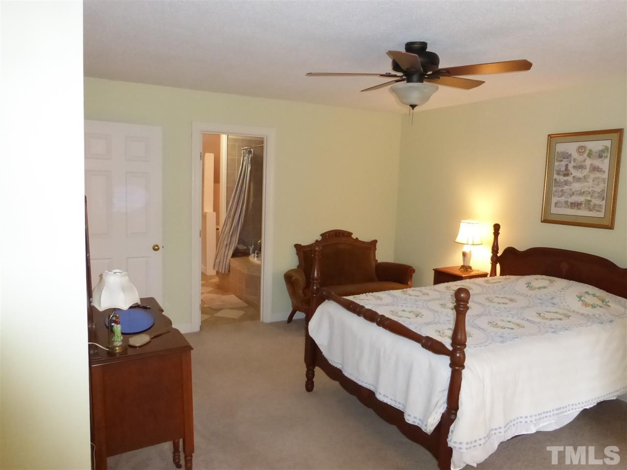 6846 Gloucester Road Raleigh, NC 27612 - Photo 15 of 18 a bedroom with a bed and a chandelier