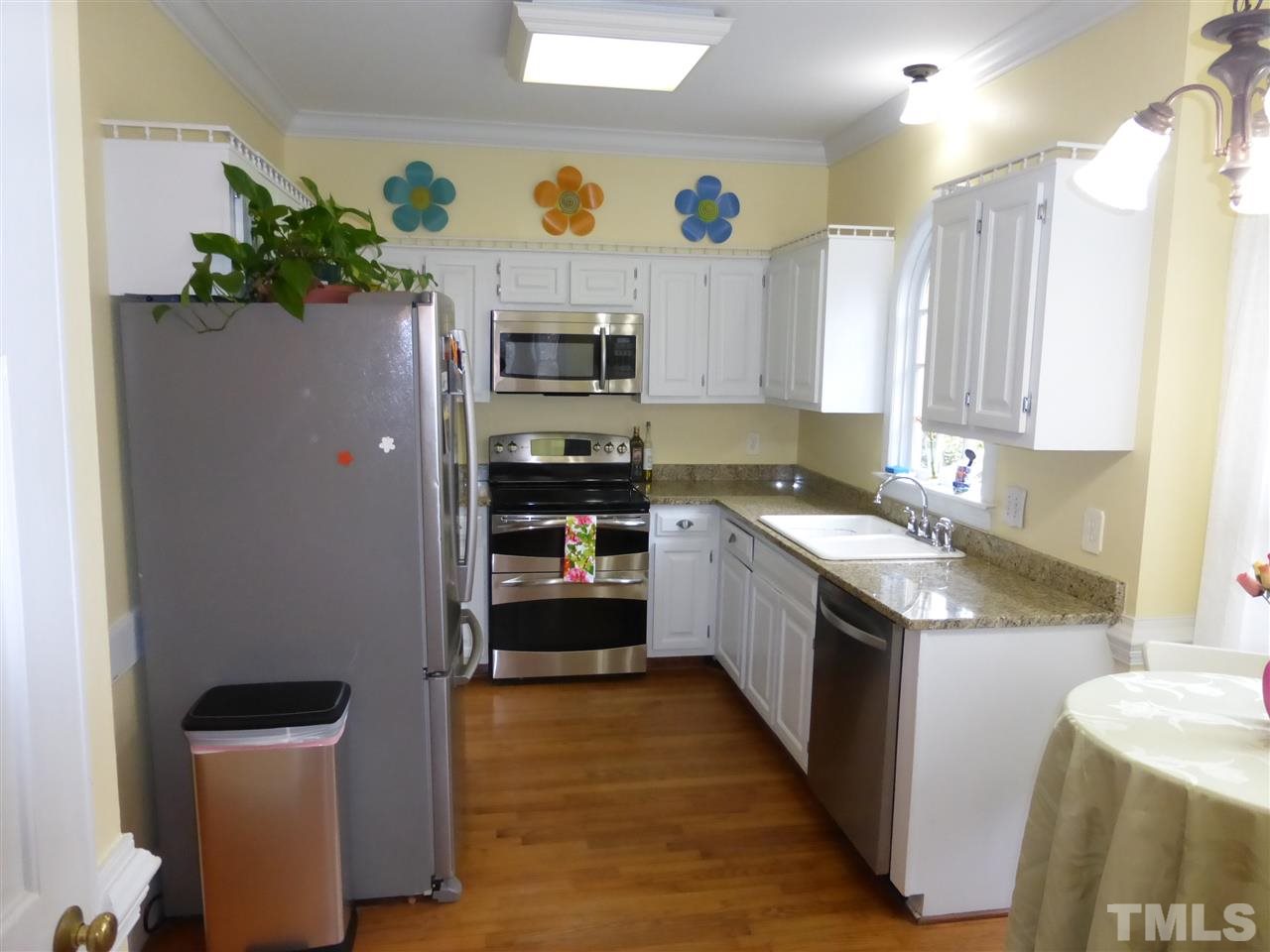 6846 Gloucester Road Raleigh, NC 27612 - Photo 5 of 18 a kitchen with stainless steel appliances granite countertop a refrigerator a sink a stove a counter space and cabinets