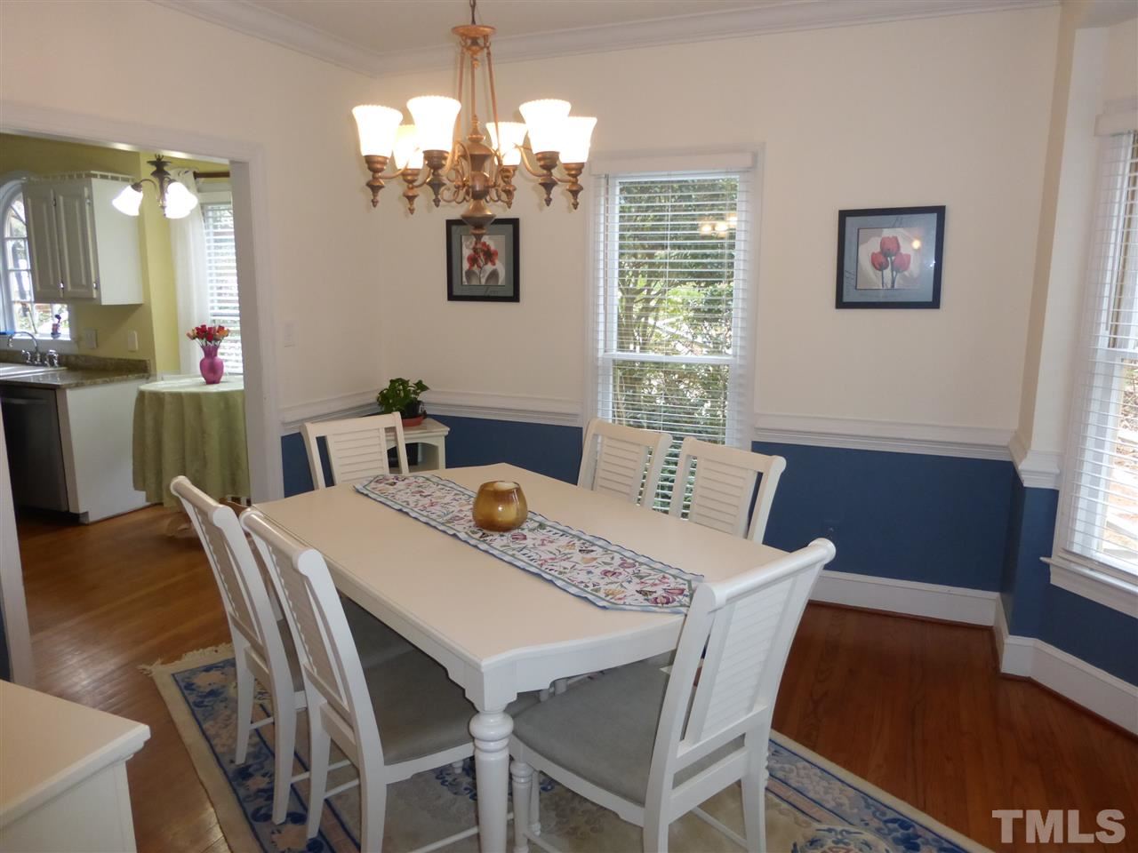 6846 Gloucester Road Raleigh, NC 27612 - Photo 6 of 18 a view of a dining room with furniture a chandelier and wooden floor