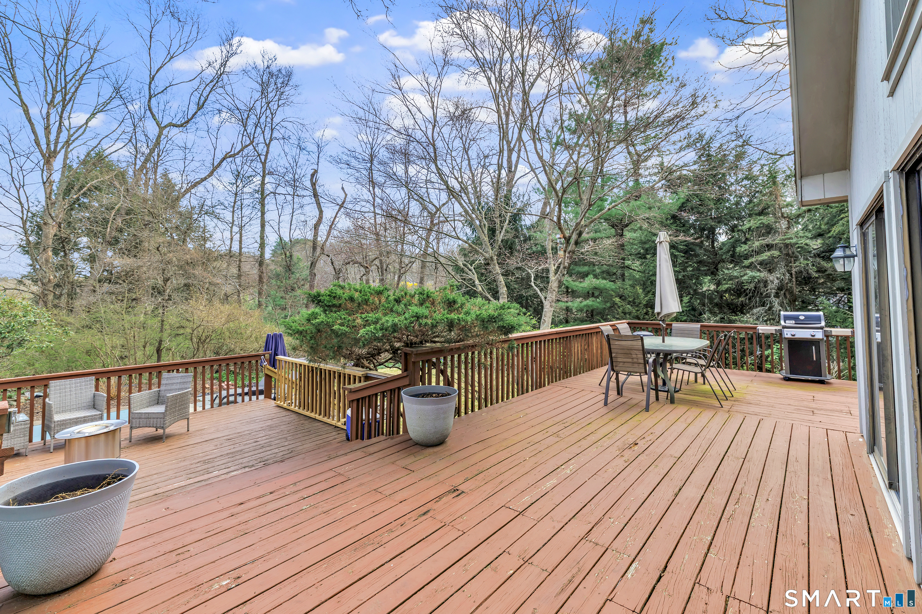 16 Mountain Road Wilton, CT 06897 - Photo 29 of 40 a view of a roof deck with table and chairs couches with wooden floor and fence