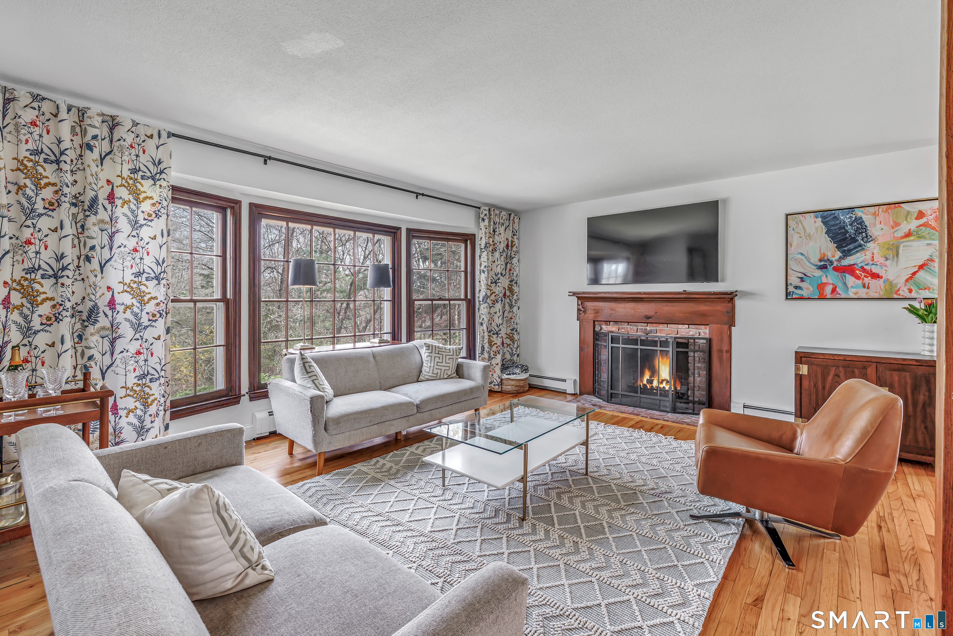 16 Mountain Road Wilton, CT 06897 - Photo 5 of 40 a living room with furniture a fireplace and a large window