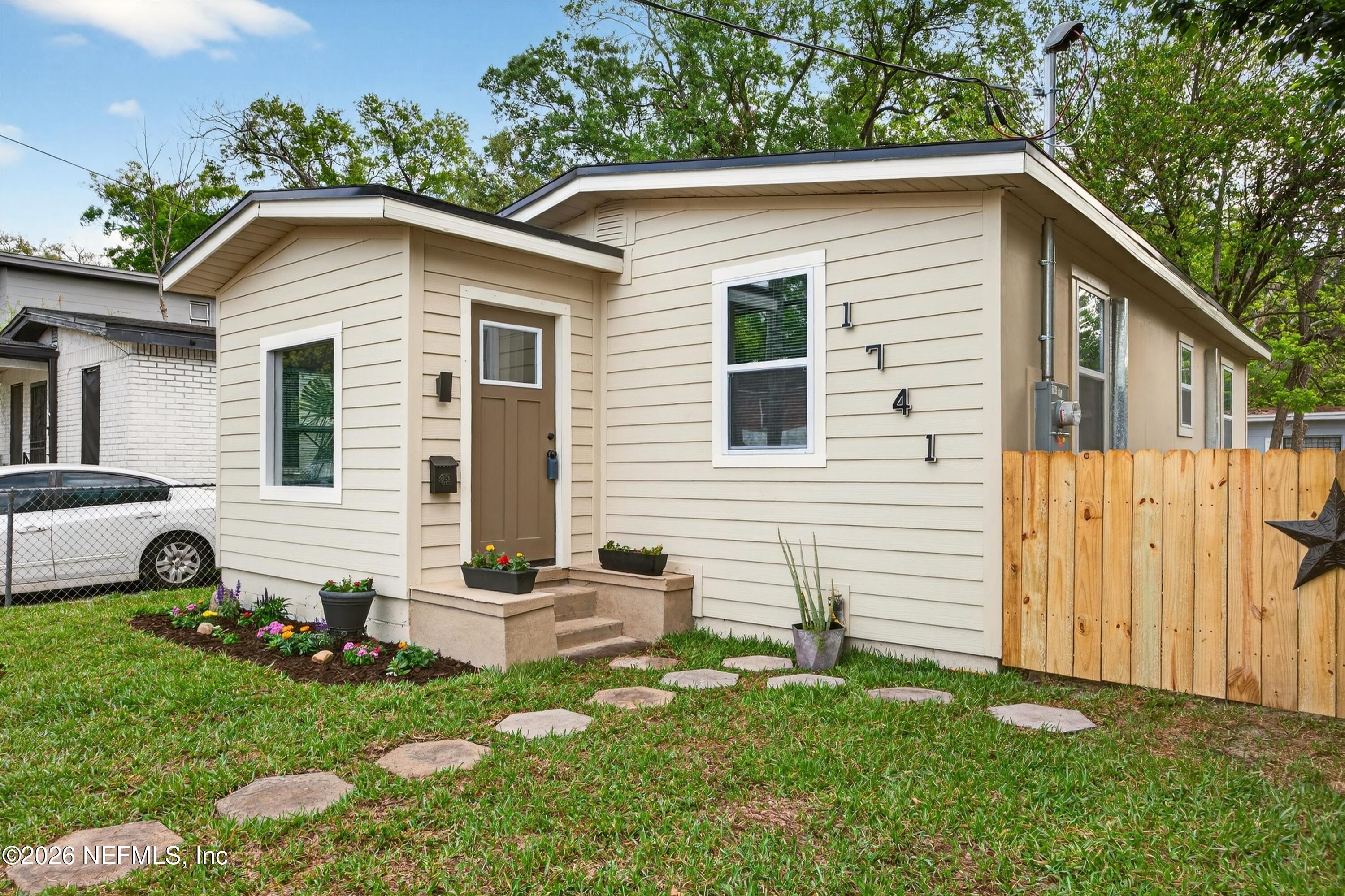 a view of a white house with a yard and a chair