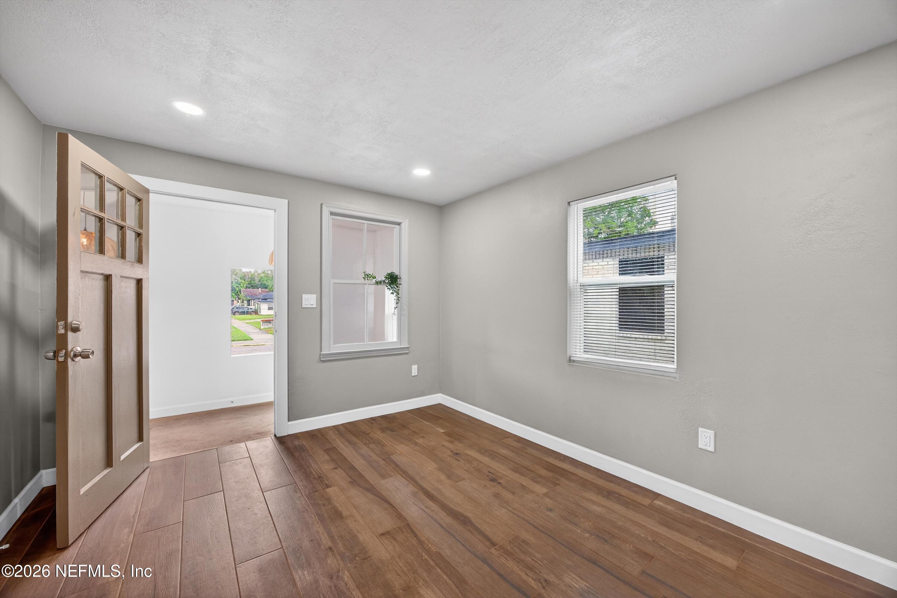 1741 Tyler Street Jacksonville, FL 32209 - Photo 6 of 25 a view of an empty room with wooden floor and a window