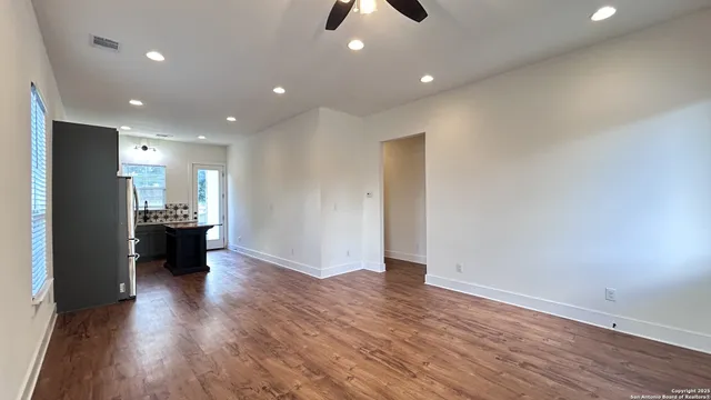 an empty room with wooden floor and window