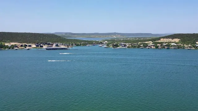 an aerial view of residential houses with outdoor space and lake view