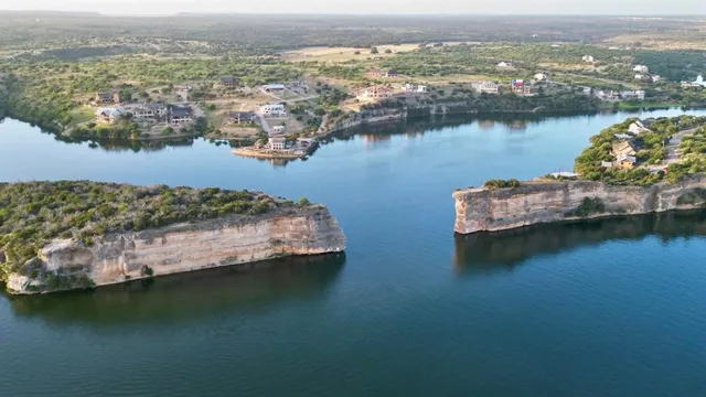 an aerial view of ocean and residential houses with outdoor space