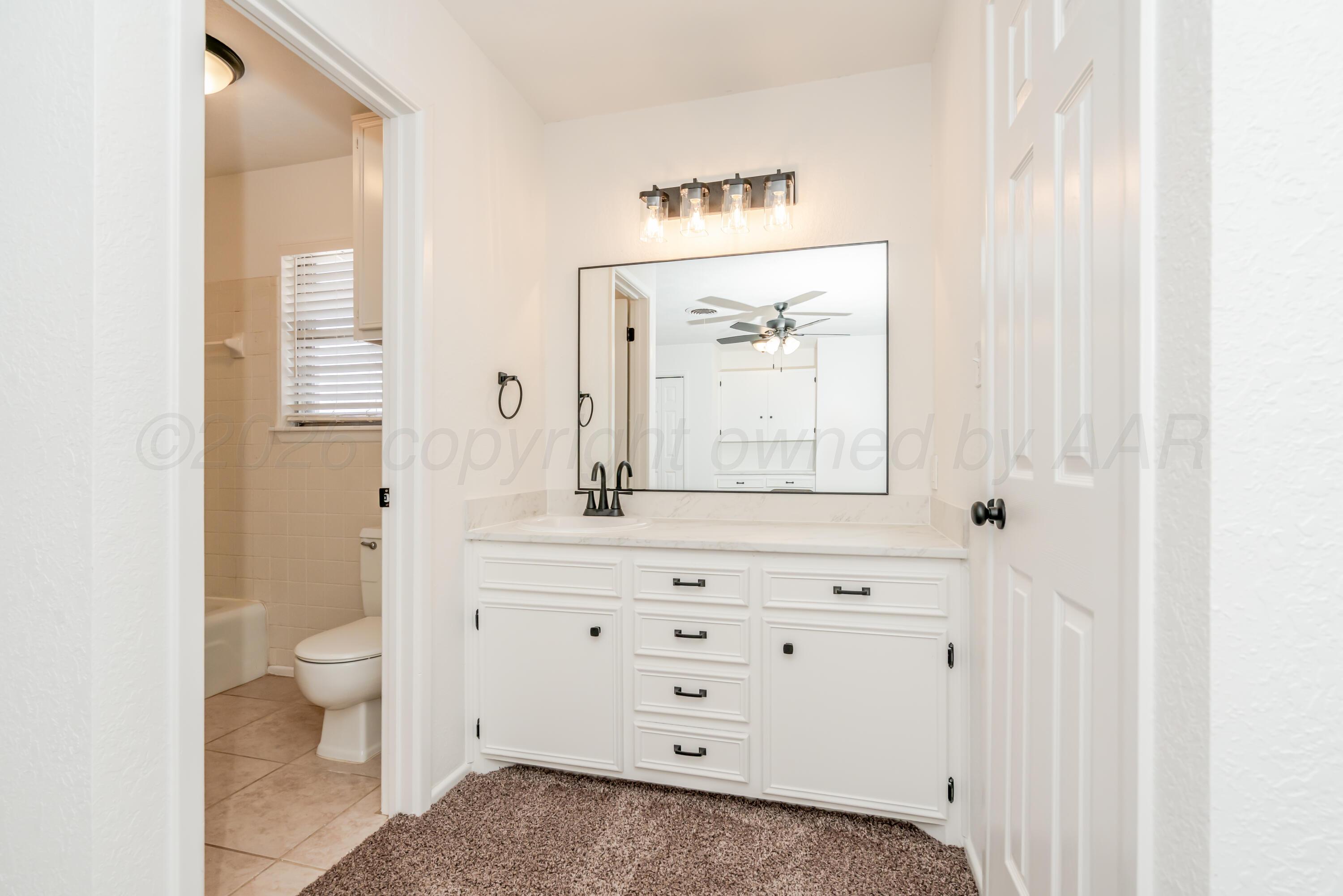 1001 5th Street Canyon, TX 79015 - Photo 20 of 34 a bathroom with a sink a toilet and a mirror