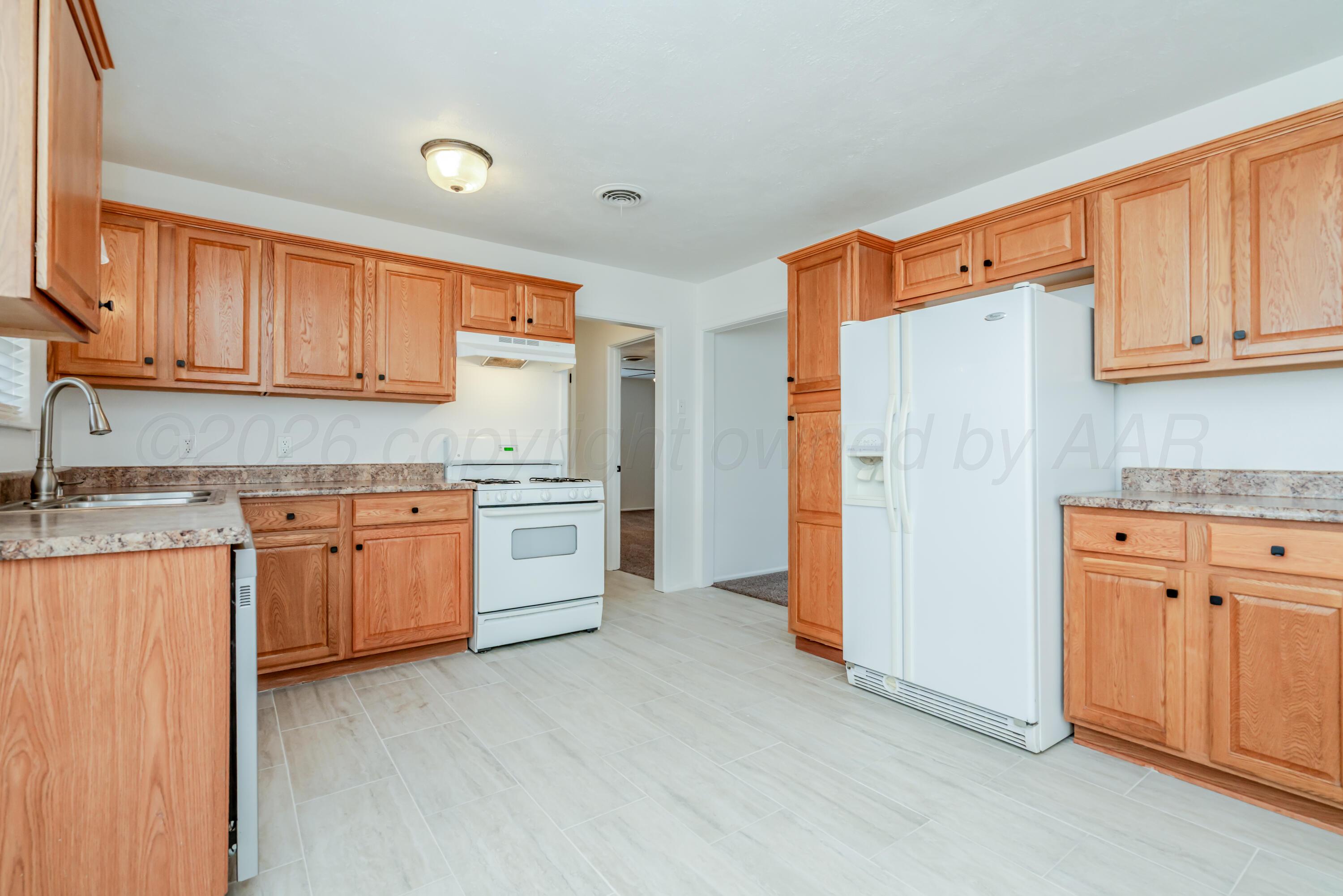1001 5th Street Canyon, TX 79015 - Photo 5 of 34 a kitchen with granite countertop white cabinets and white appliances