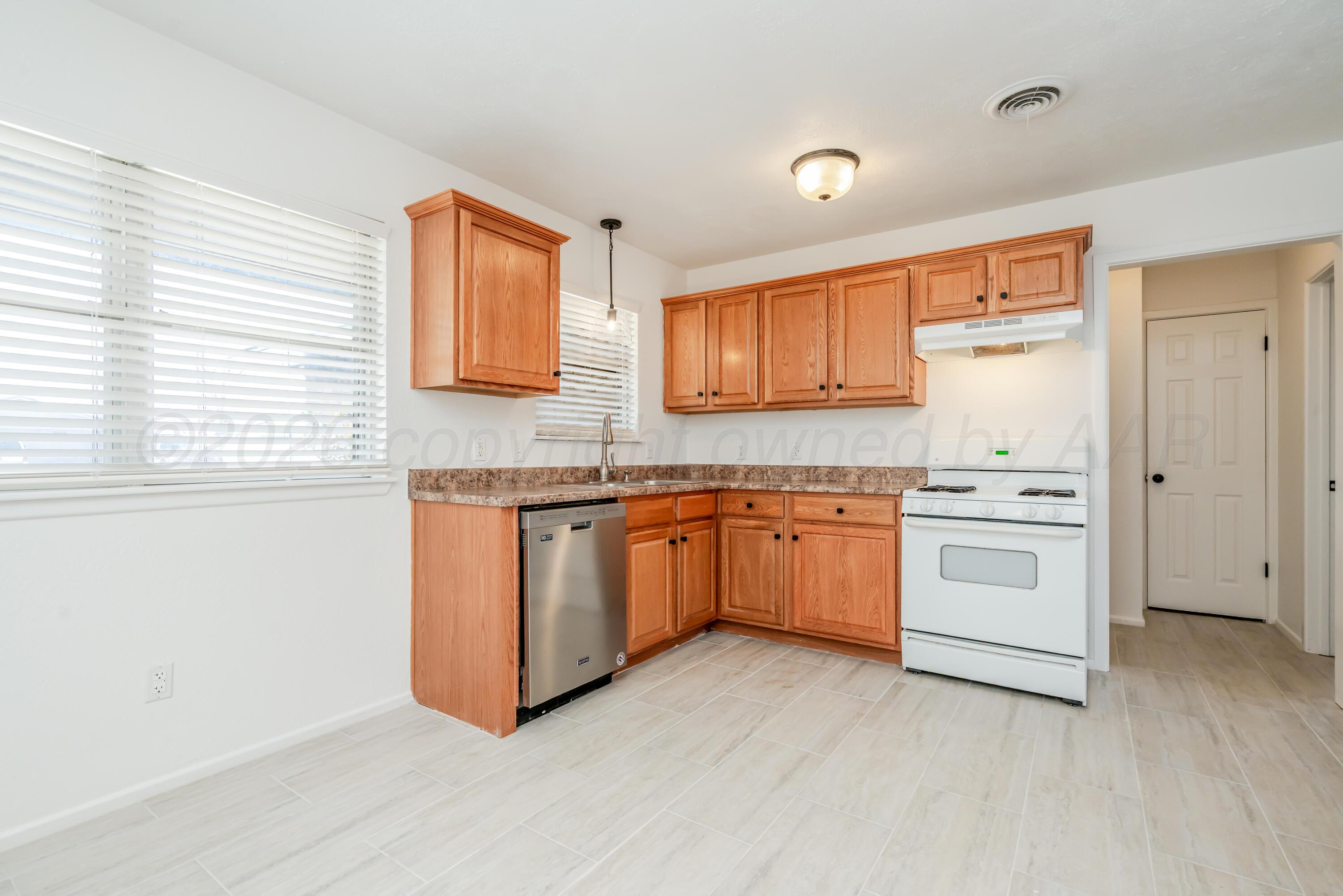 1001 5th Street Canyon, TX 79015 - Photo 6 of 34 a kitchen with granite countertop white cabinets and white appliances