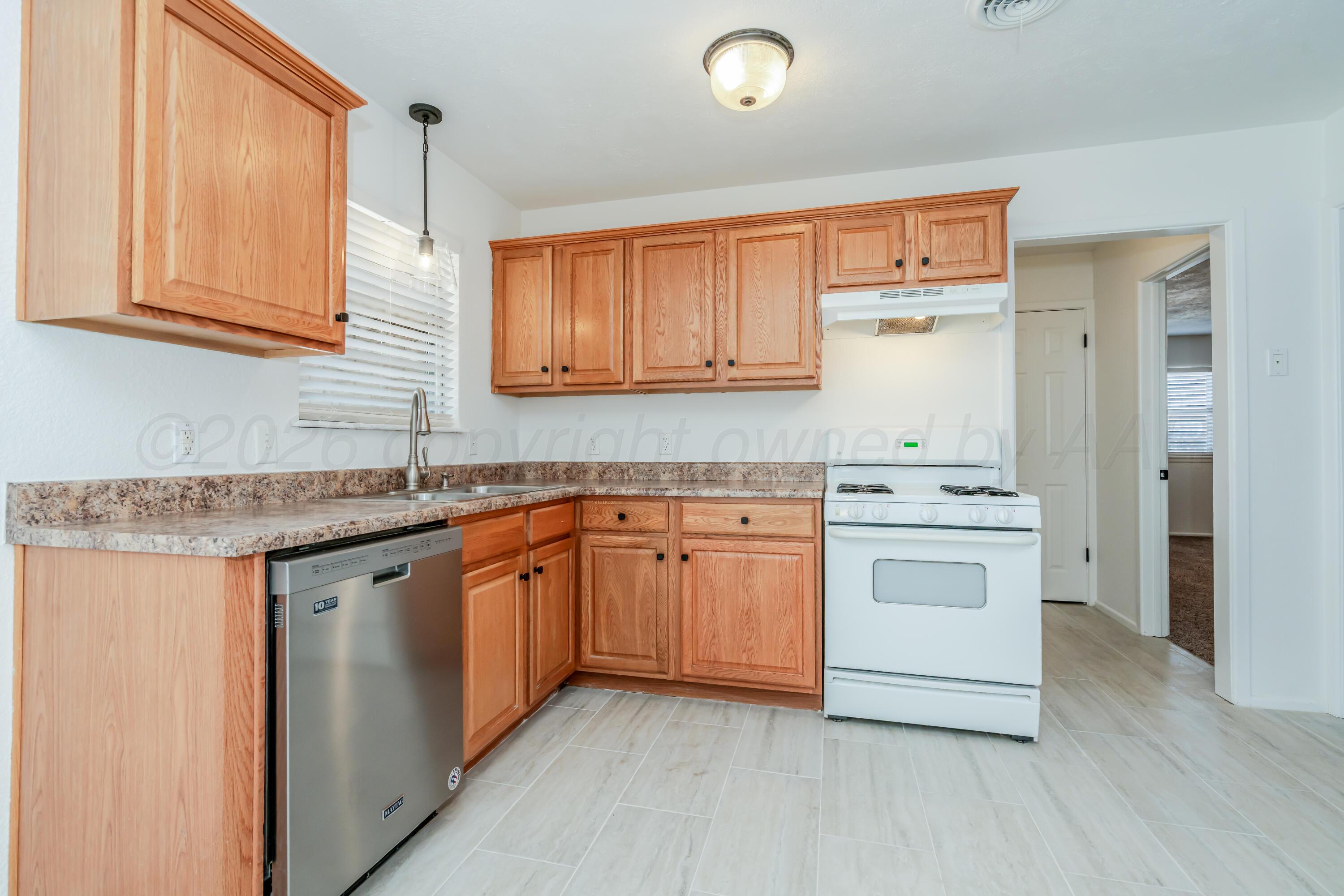 1001 5th Street Canyon, TX 79015 - Photo 7 of 34 a kitchen with granite countertop white cabinets and white appliances