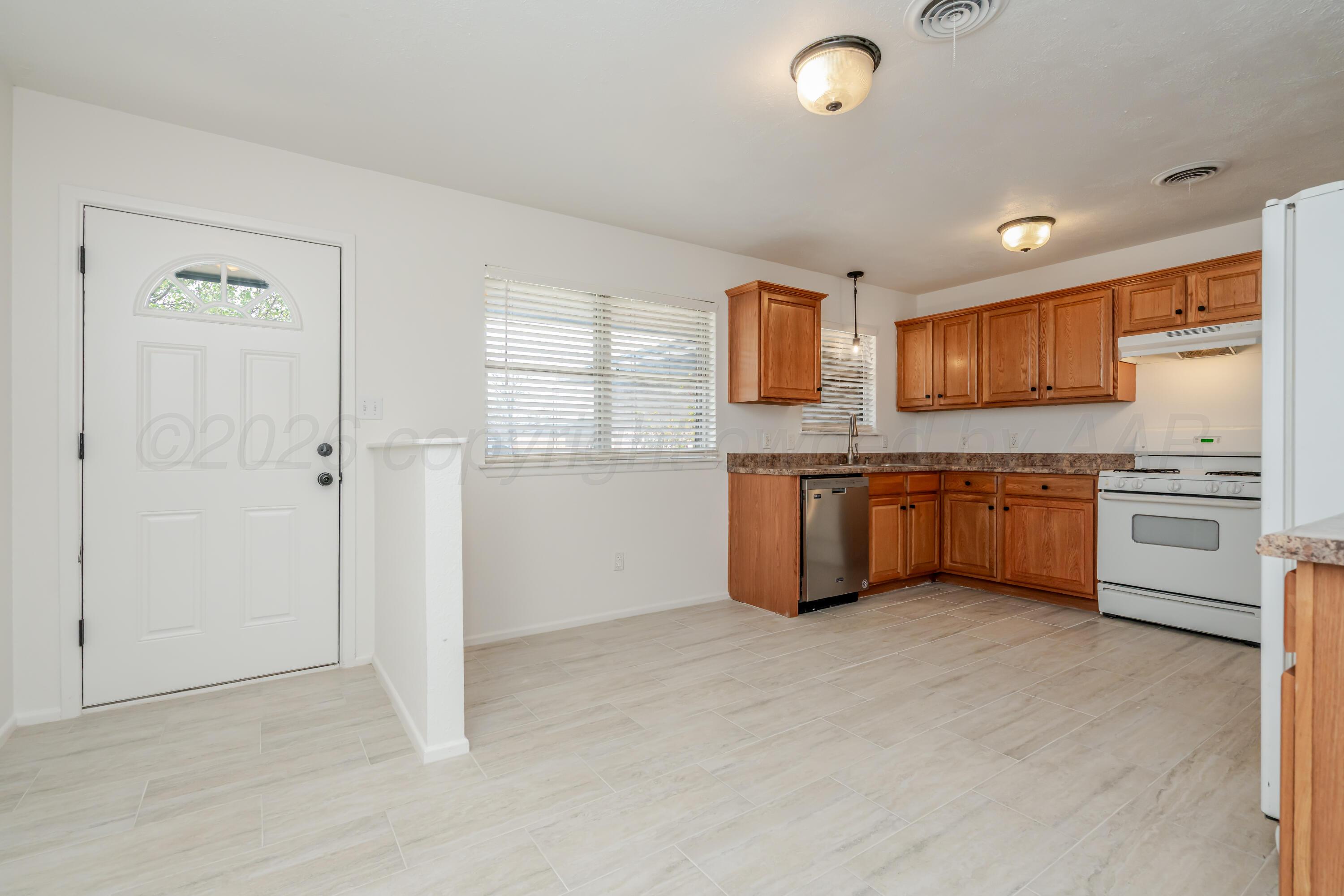 1001 5th Street Canyon, TX 79015 - Photo 8 of 34 a kitchen with stainless steel appliances a sink and a refrigerator