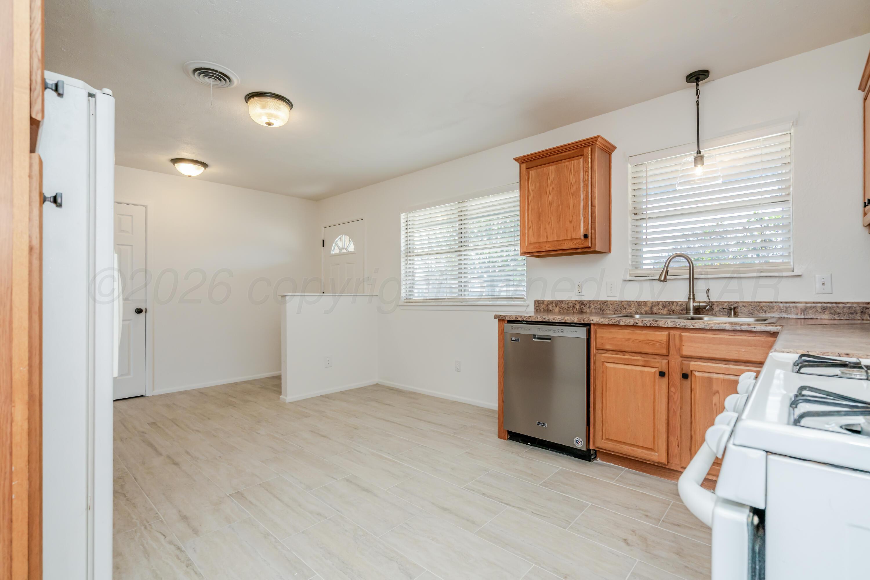 1001 5th Street Canyon, TX 79015 - Photo 9 of 34 a kitchen with granite countertop white cabinets and white appliances