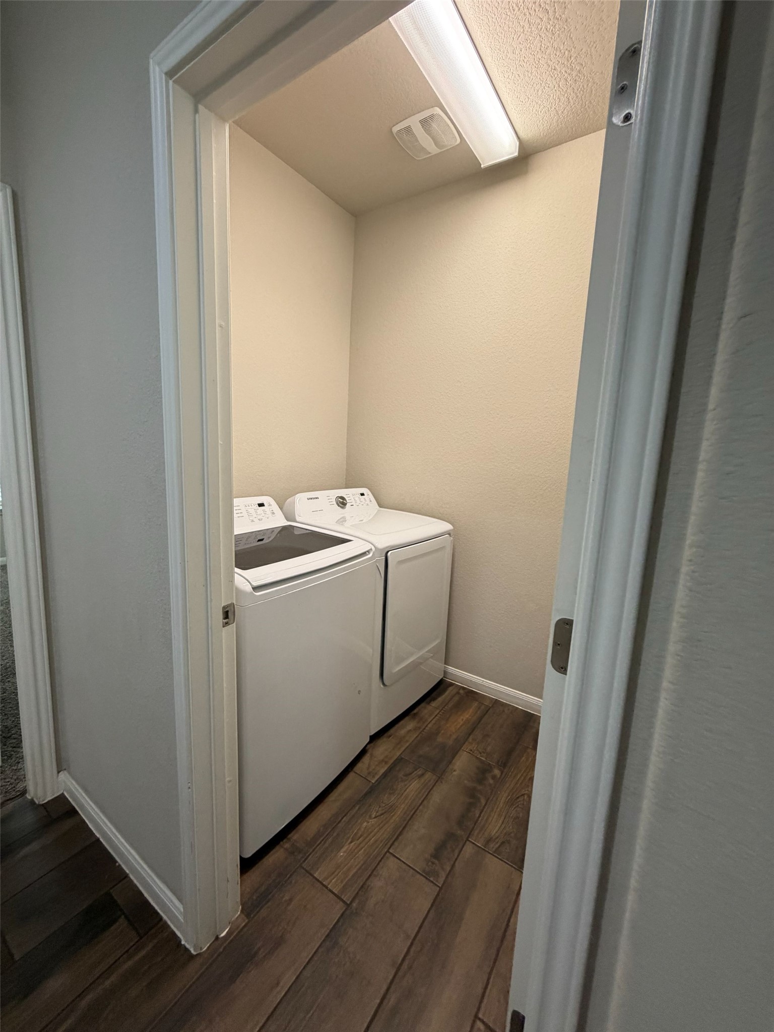 248 Falling Star Lane Georgetown, TX 78628 - Photo 7 of 16 A dedicated utility space with rich wood-look flooring, ready for household tasks.