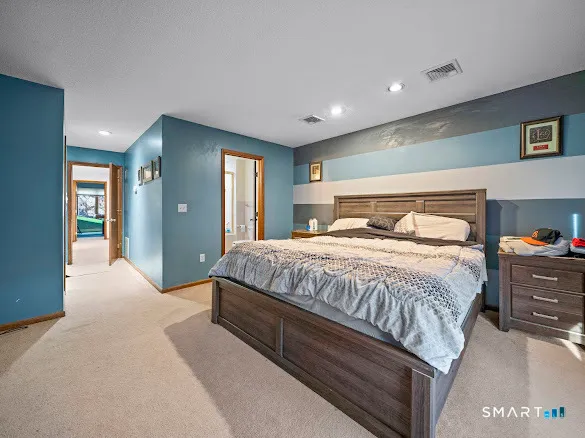 a bedroom with a large bed and a chandelier