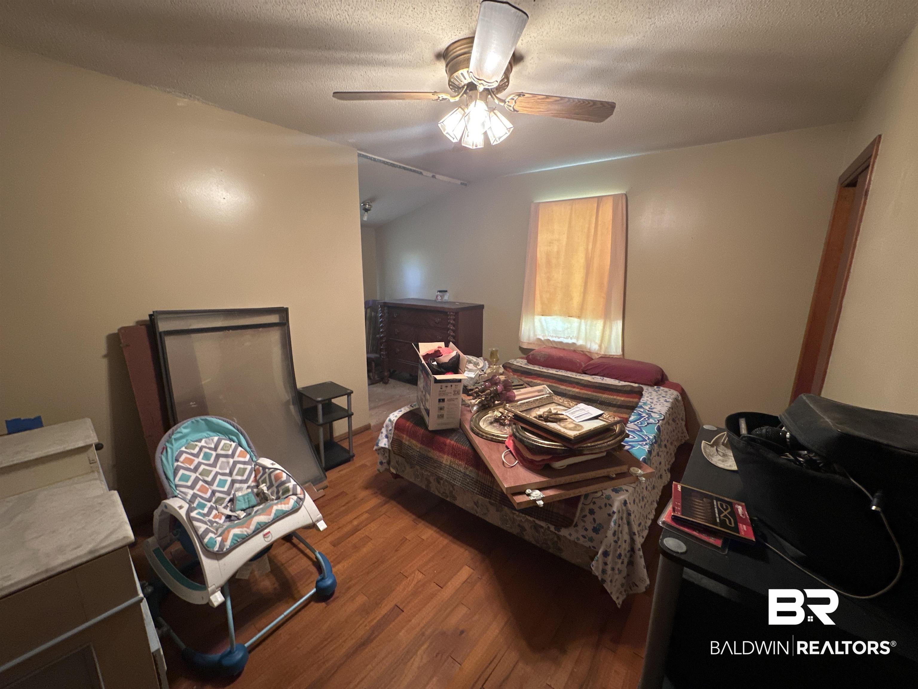 9520 C Four Mile Road Irvington, AL 36544 - Photo 22 of 32 Bedroom with hardwood / wood-style floors, a textured ceiling, vaulted ceiling, and ceiling fan