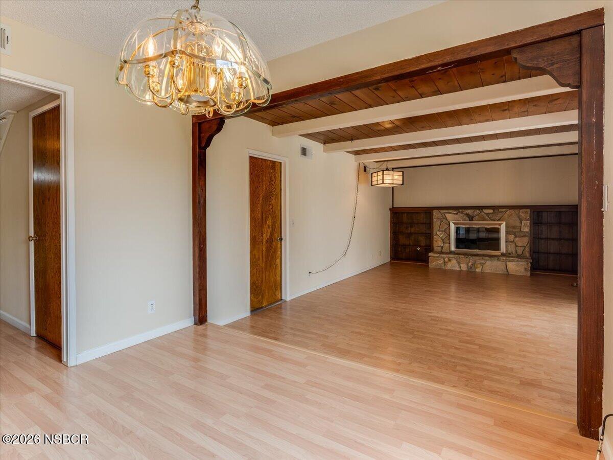 360 Tallyho Road Santa Maria, CA 93455 - Photo 24 of 72 a view of a livingroom with a fireplace a chandelier and wooden floor